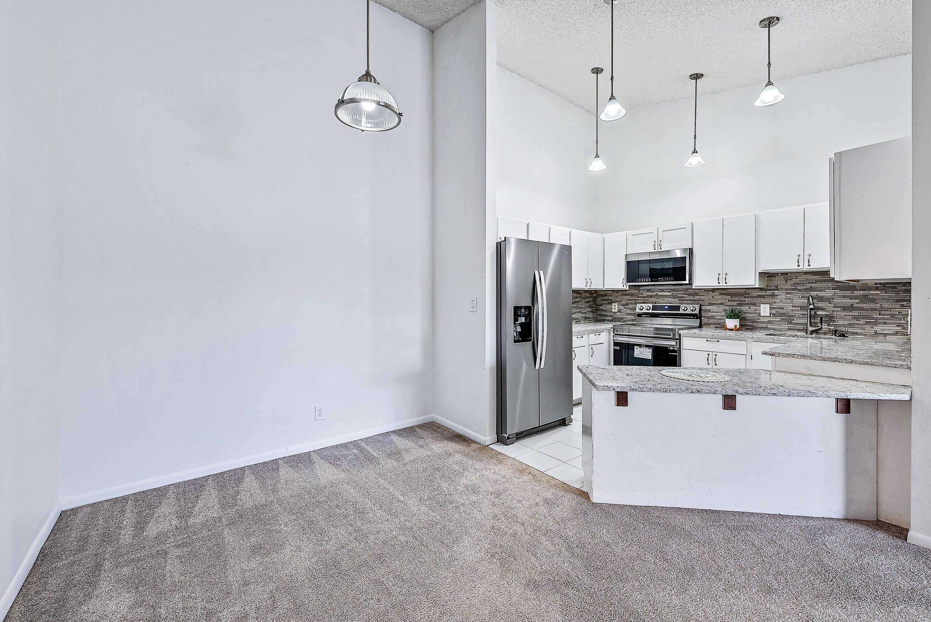 a kitchen with stainless steel appliances a refrigerator sink and white cabinets