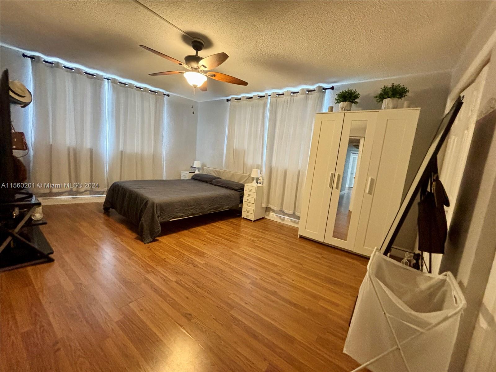 a spacious bedroom with a bed and a mirror