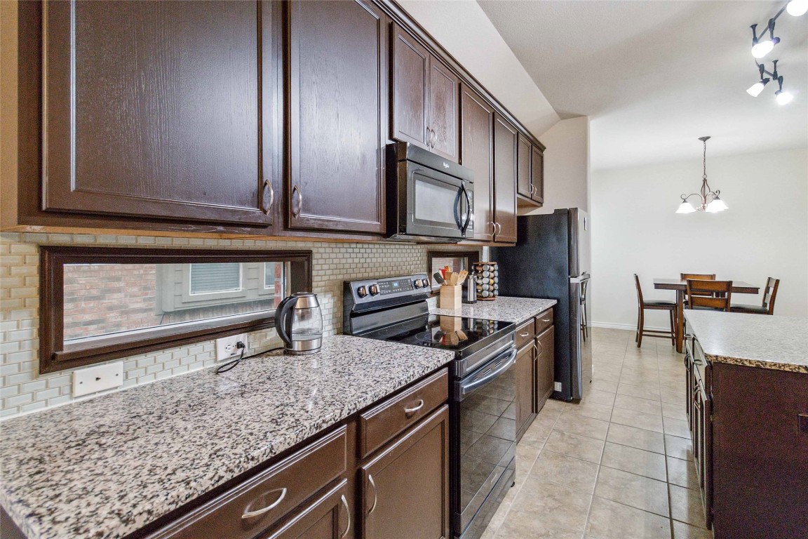 a kitchen with stainless steel appliances granite countertop a sink stove and cabinets