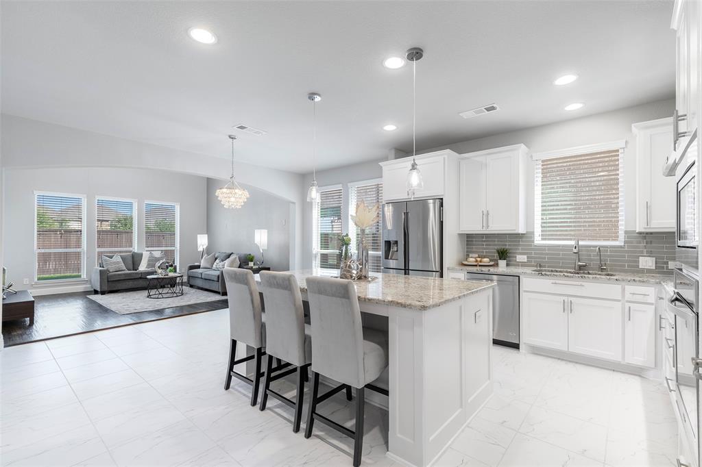 a kitchen with stainless steel appliances kitchen island granite countertop a sink and cabinets