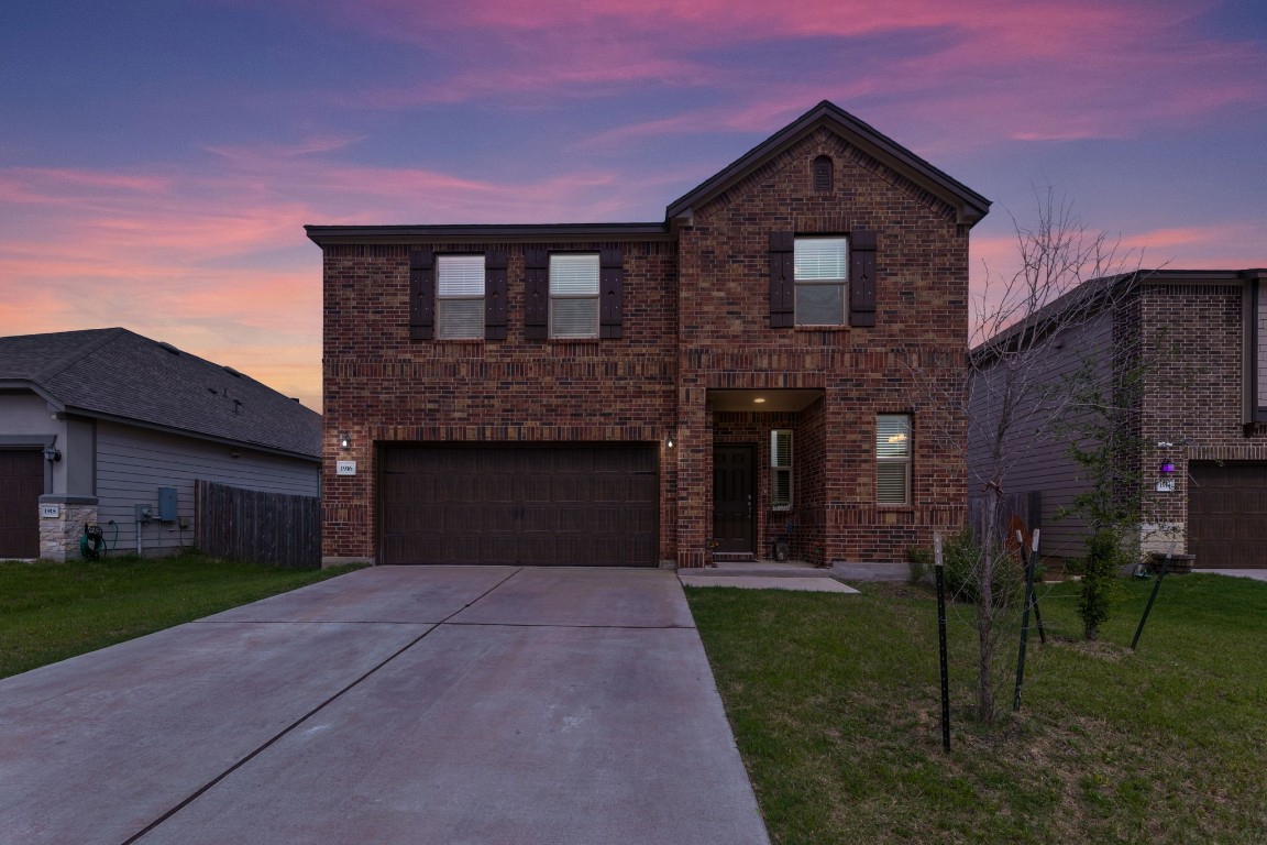 a front view of a house with a yard and garage