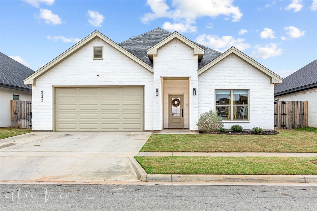 a view of a house with a yard and garage