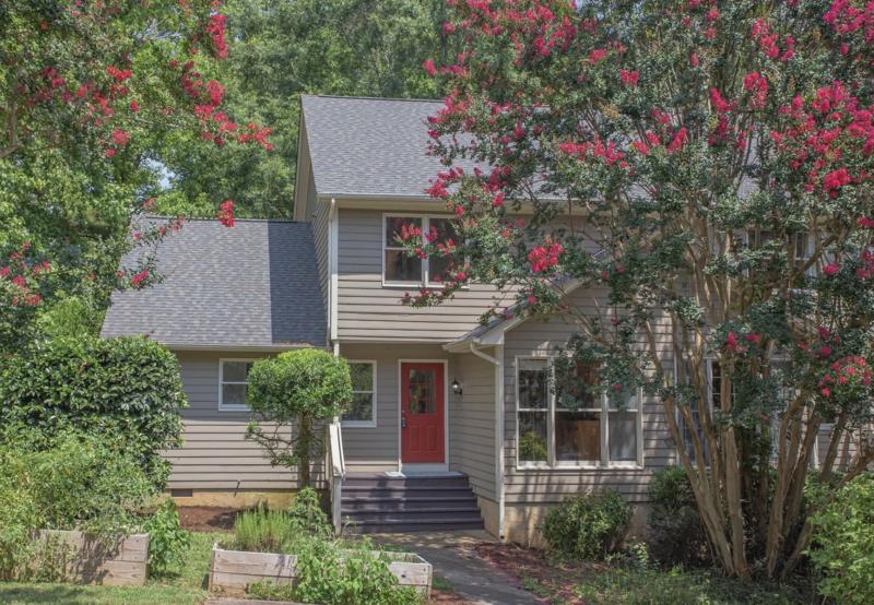 a front view of a house with a yard and tree s