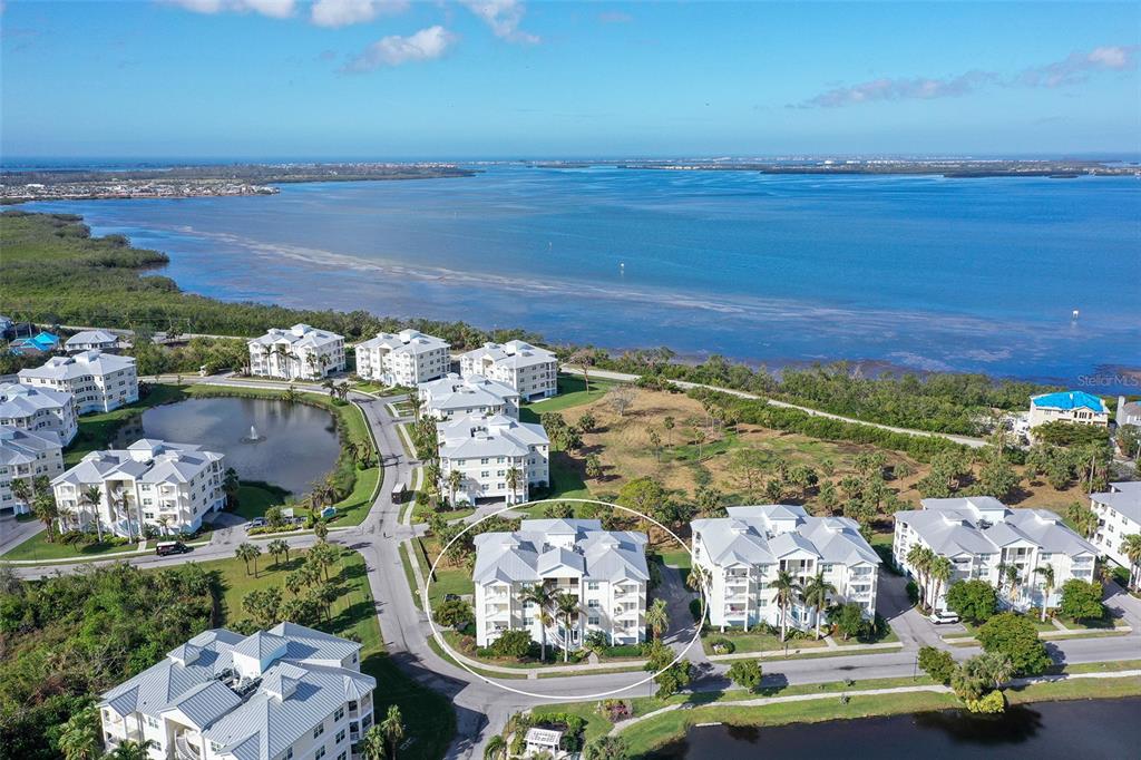 an aerial view of ocean and residential houses with outdoor space