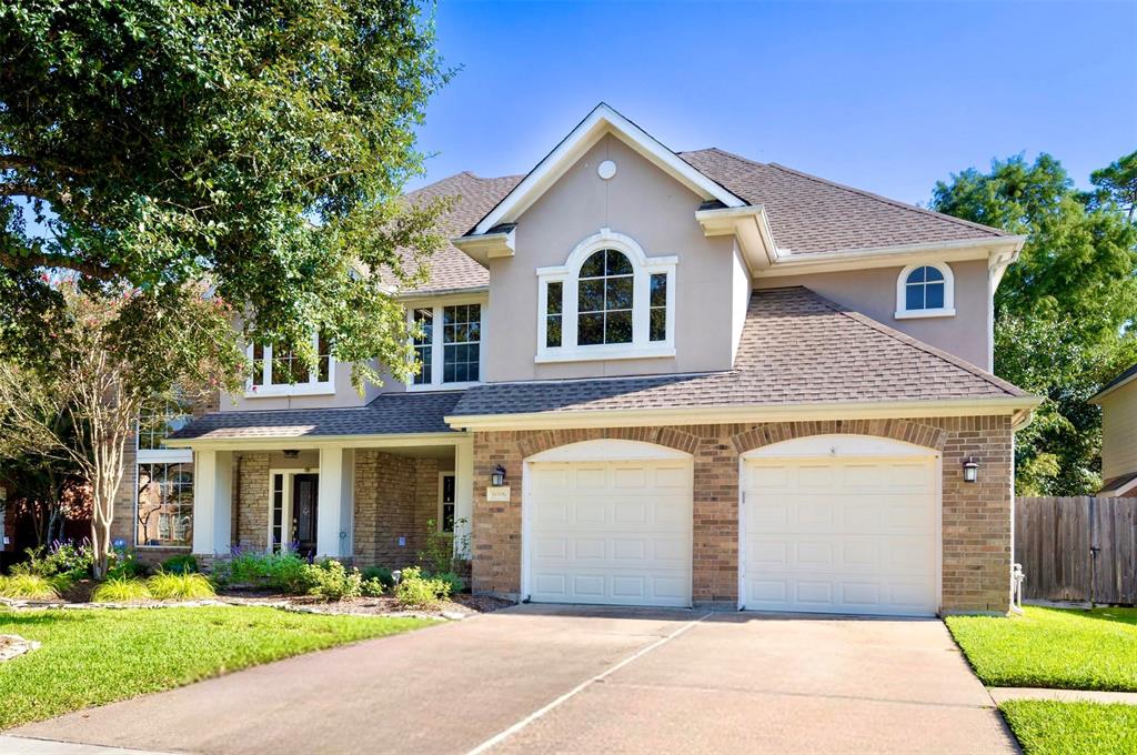 a front view of a house with a yard and trees