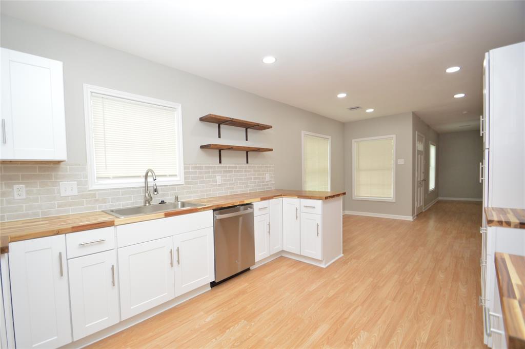 a large kitchen with granite countertop a sink and dishwasher stove top oven