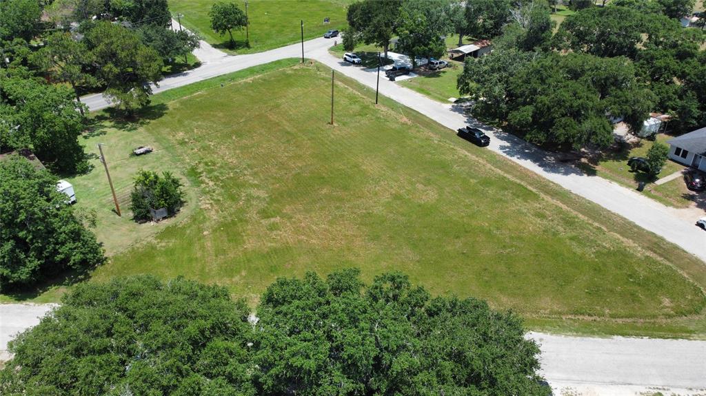 an aerial view of residential houses with outdoor space and trees all around