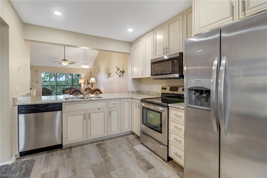 a kitchen with stainless steel appliances granite countertop a stove a sink and a refrigerator