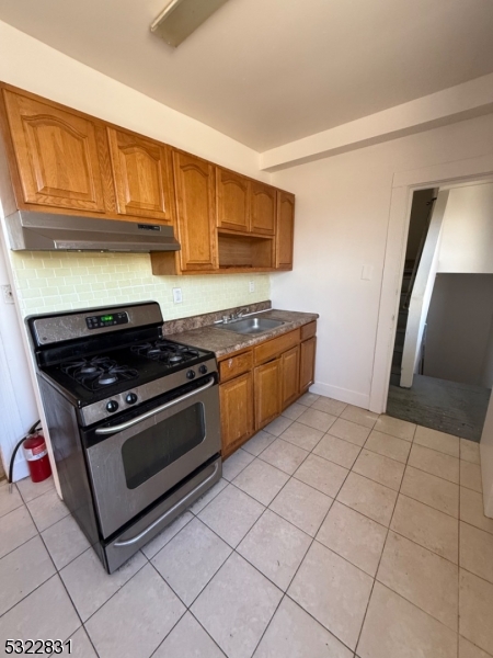 a kitchen with granite countertop a stove a sink and a microwave