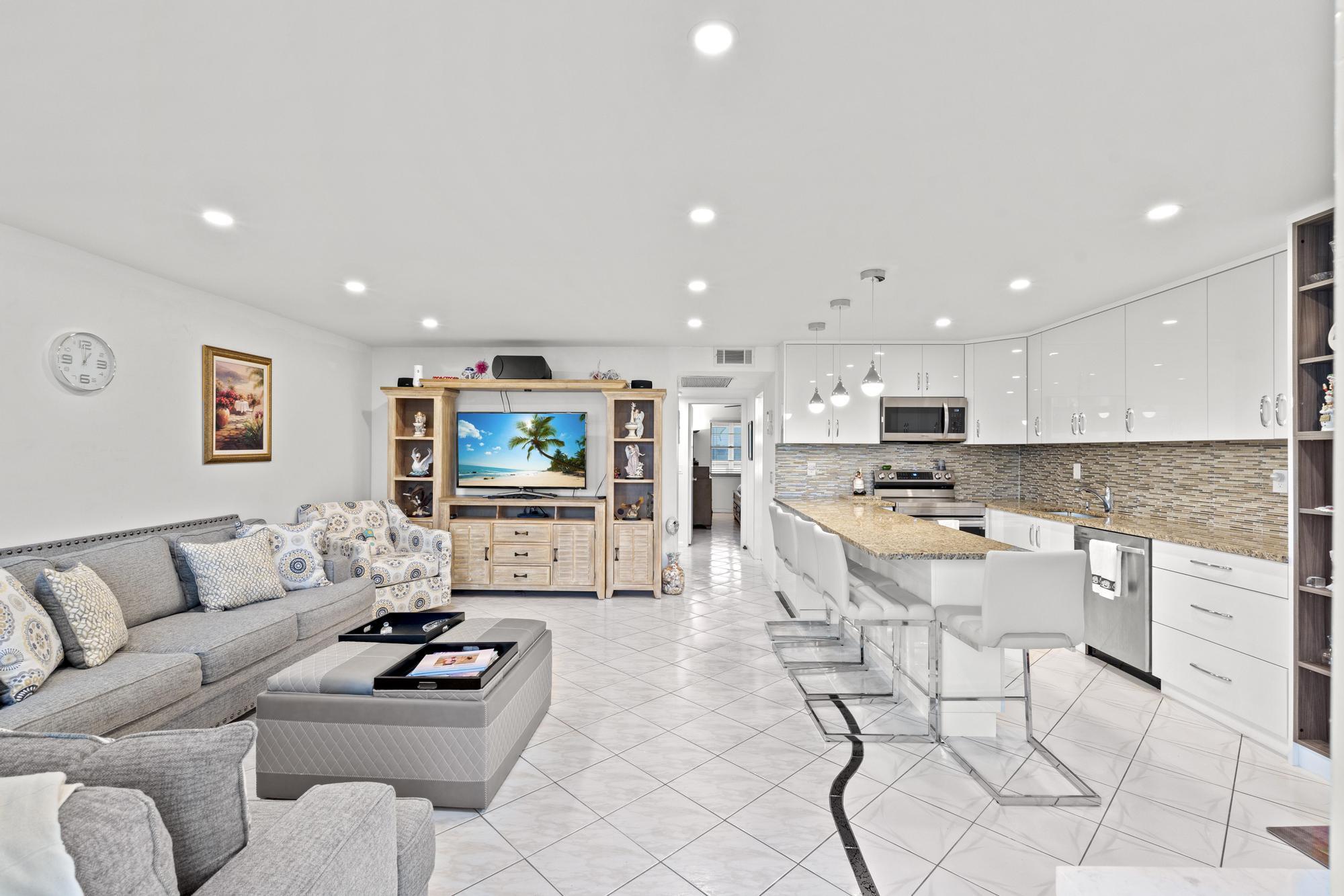 a living room with furniture kitchen view and a flat screen tv