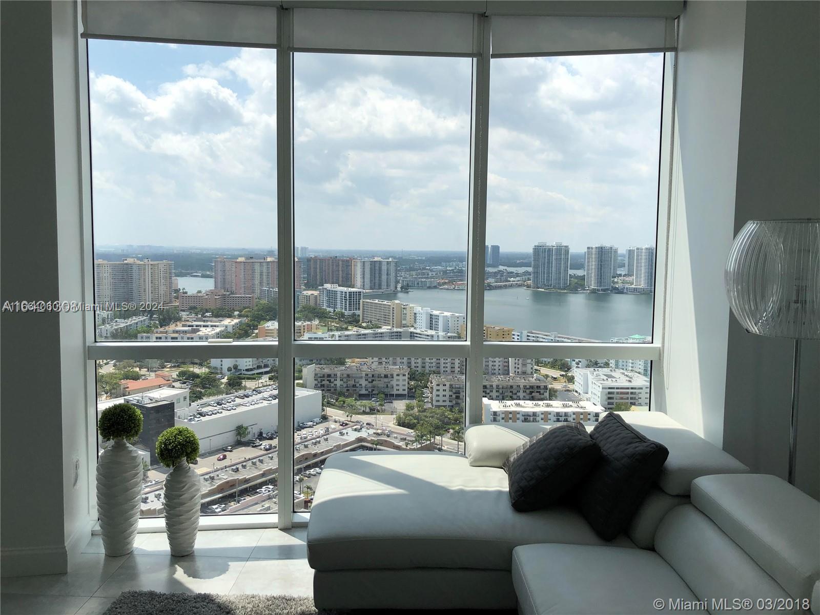 a living room filled with furniture and a floor to ceiling window