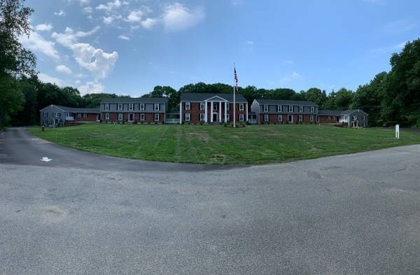 a view of a big house with a big yard and a large trees