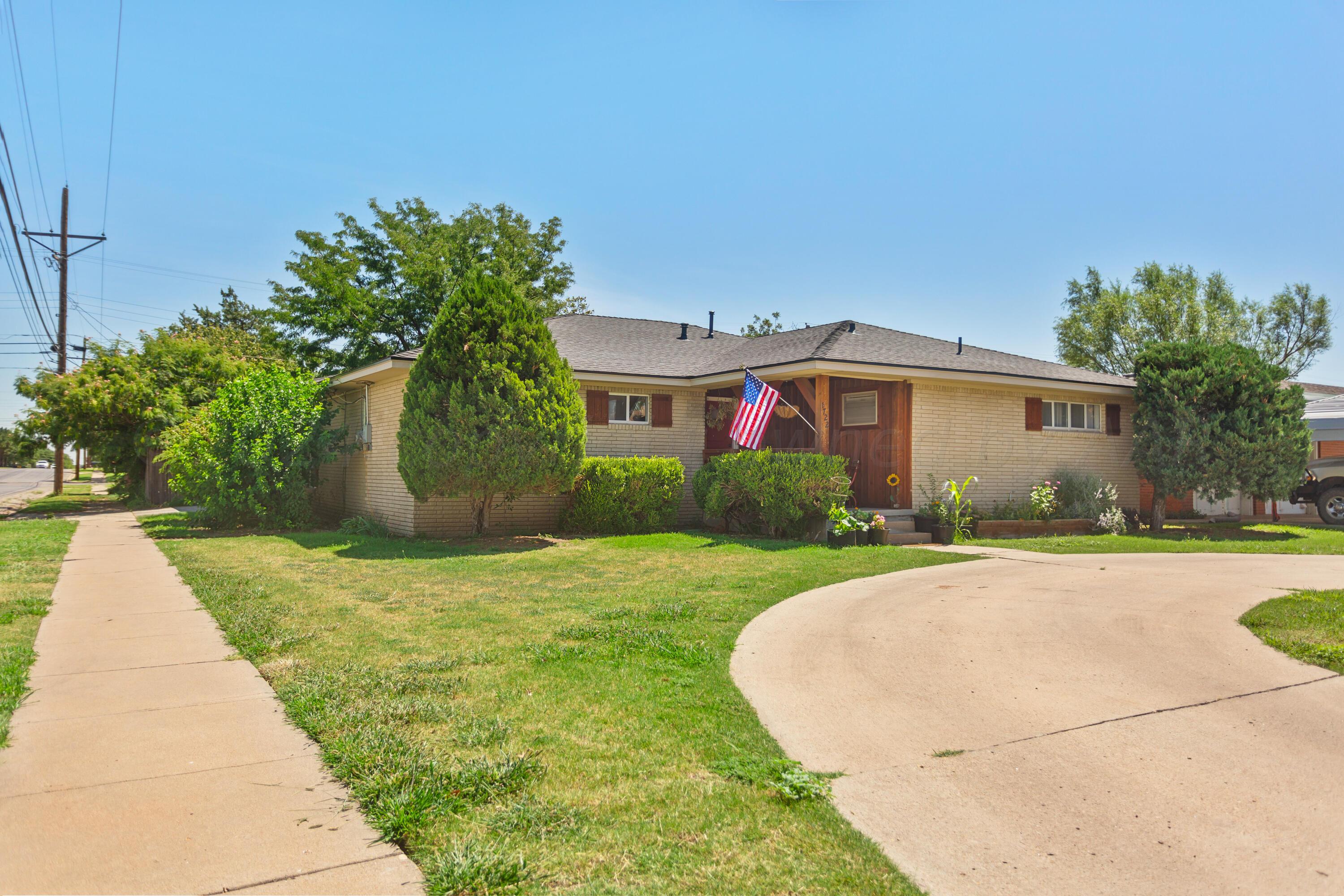 a front view of a house with a yard and trees