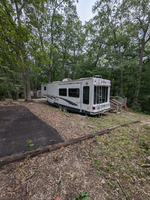 a view of a house with backyard and trees