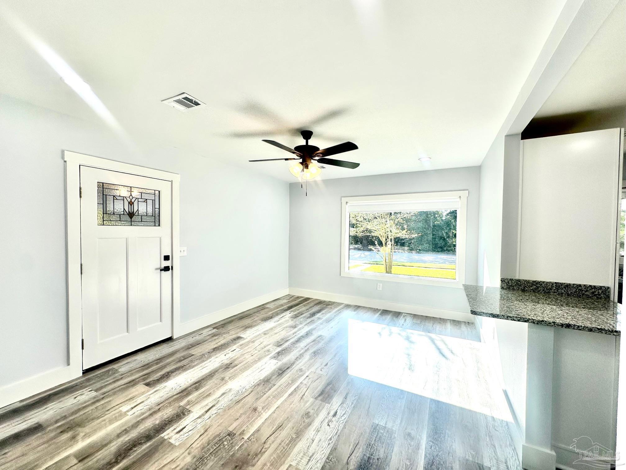 a view of a room with wooden floor and a window