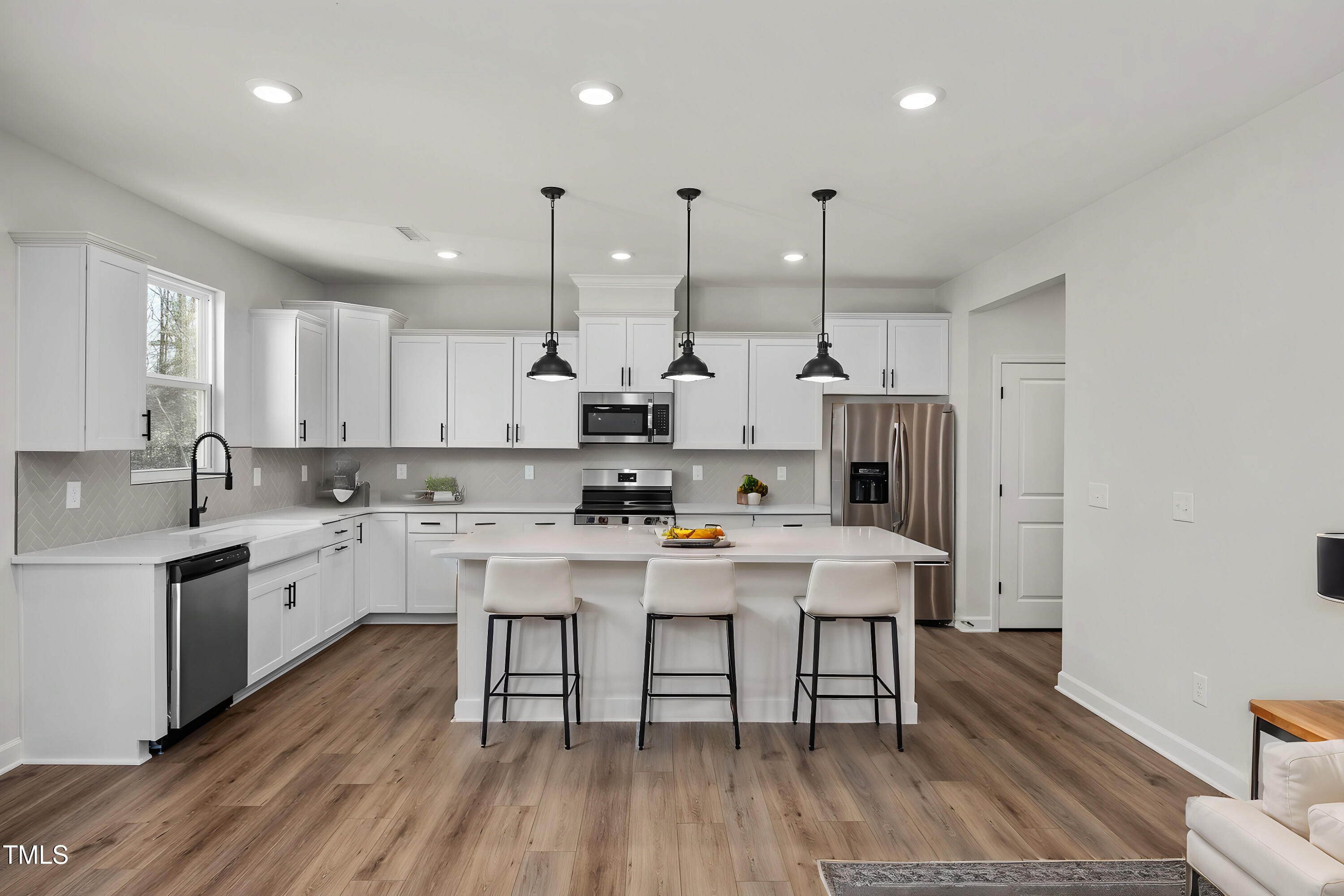 a kitchen with white cabinets stainless steel appliances and wooden floor