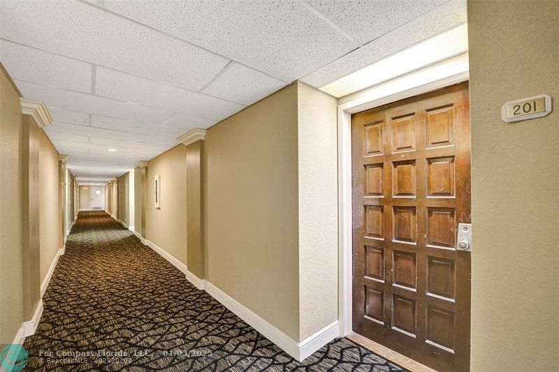 a view of a hallway with wooden floor and a cabinet