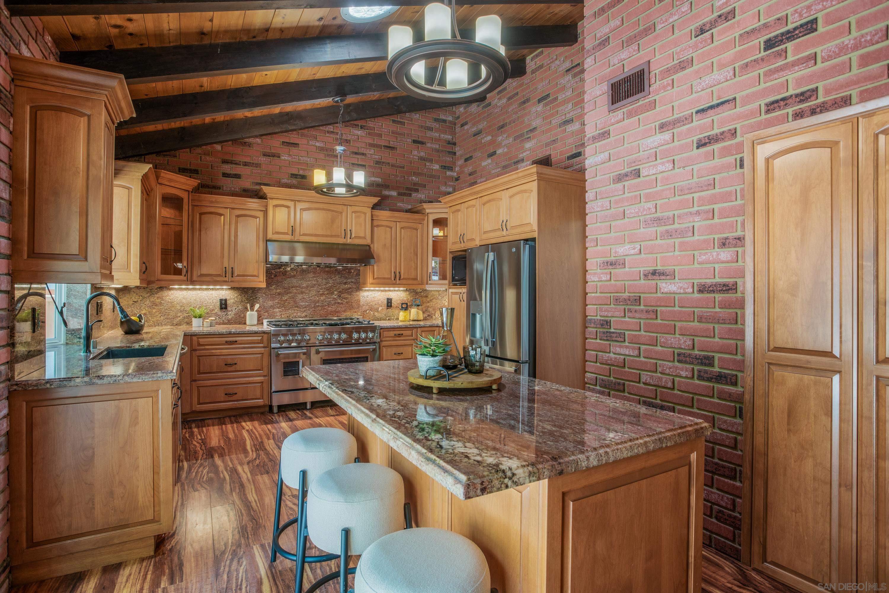 a kitchen with stainless steel appliances granite countertop a sink a stove and cabinets