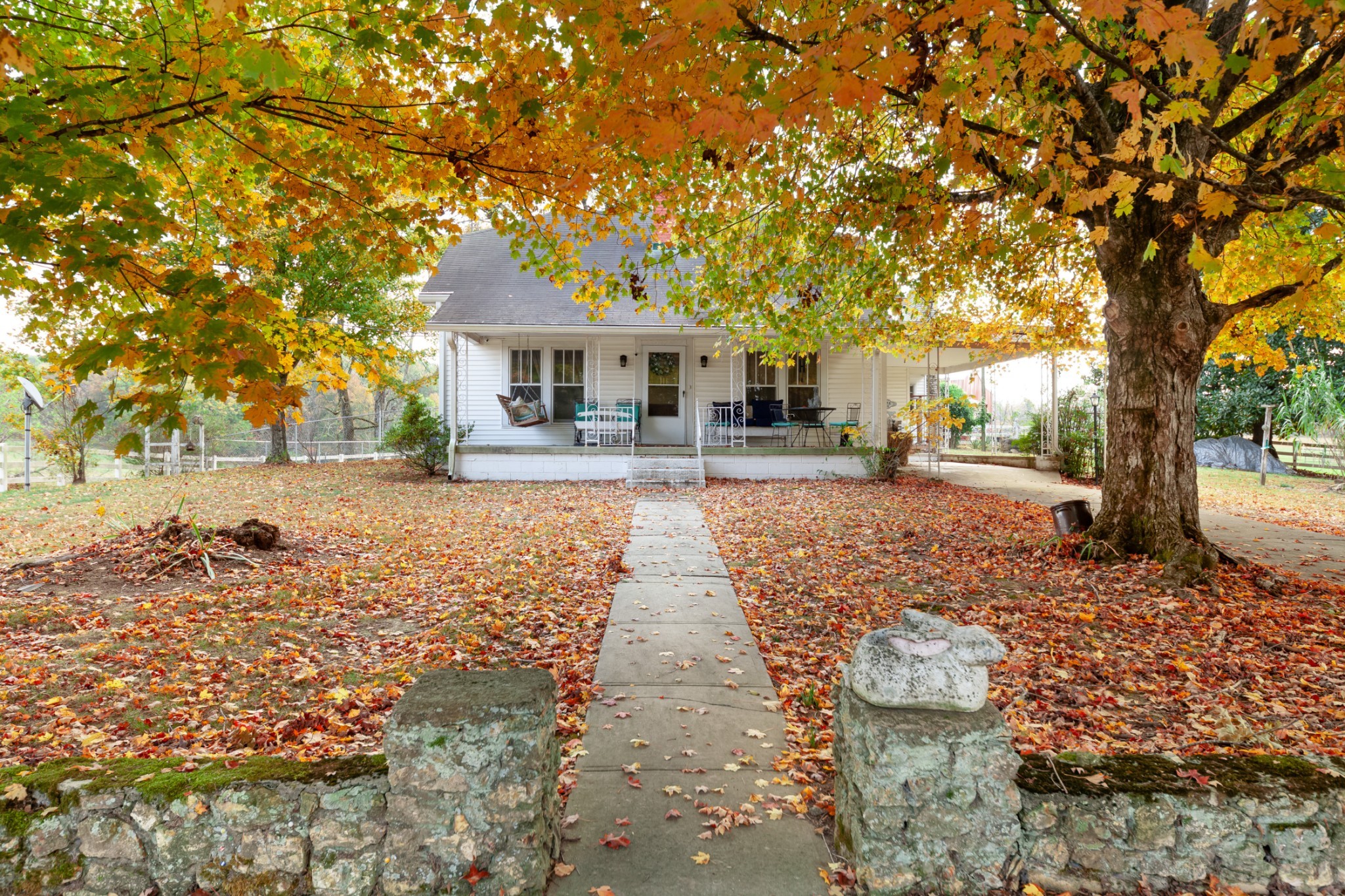 a front view of a house with yard tree and wooden fence