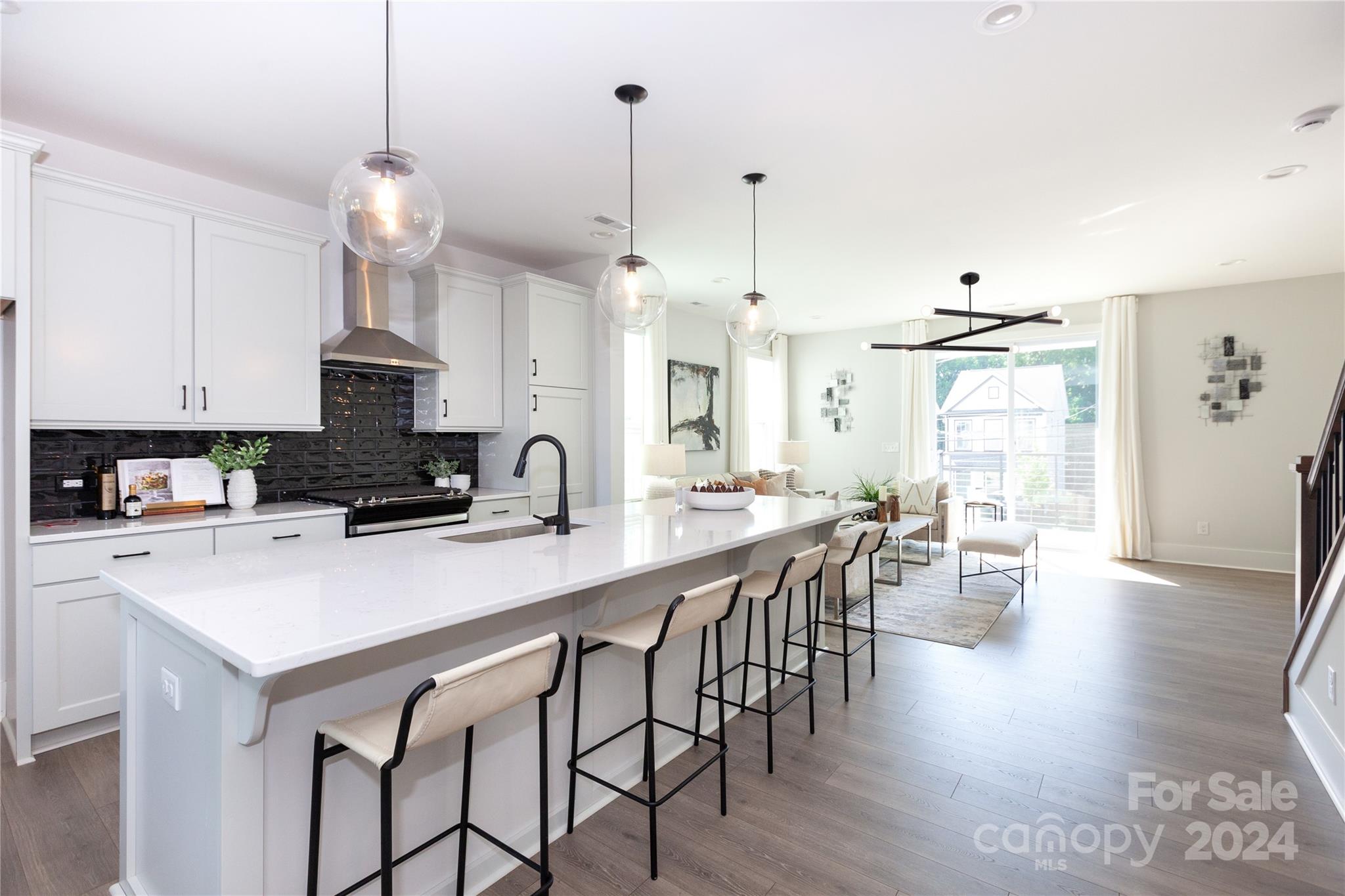 a large kitchen with kitchen island a dining table chairs and a chandelier