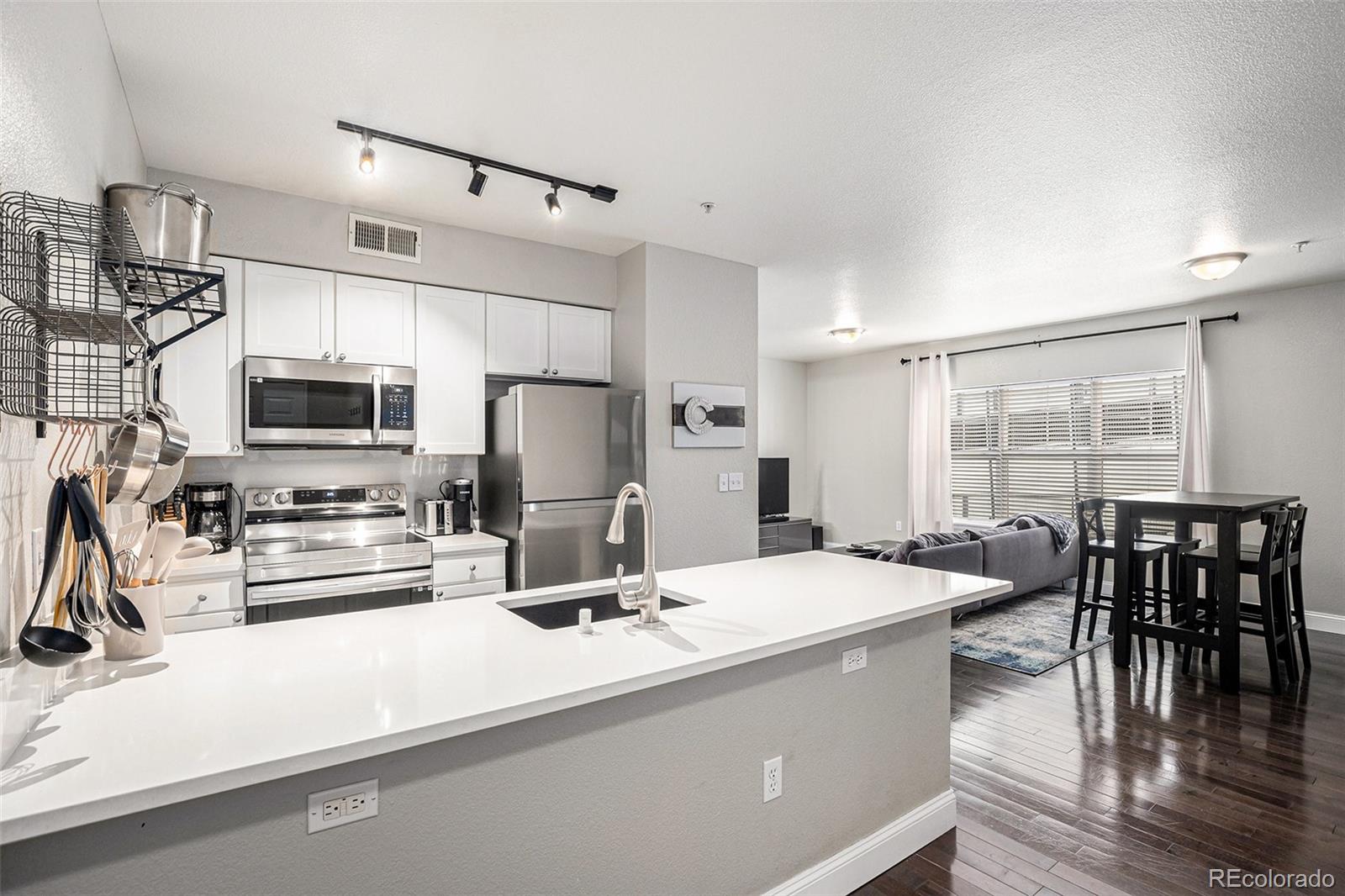 a room with stainless steel appliances kitchen island granite countertop a sink and cabinets