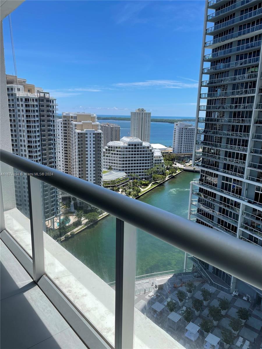 a view of balcony with a couple of cars parked in front of a building