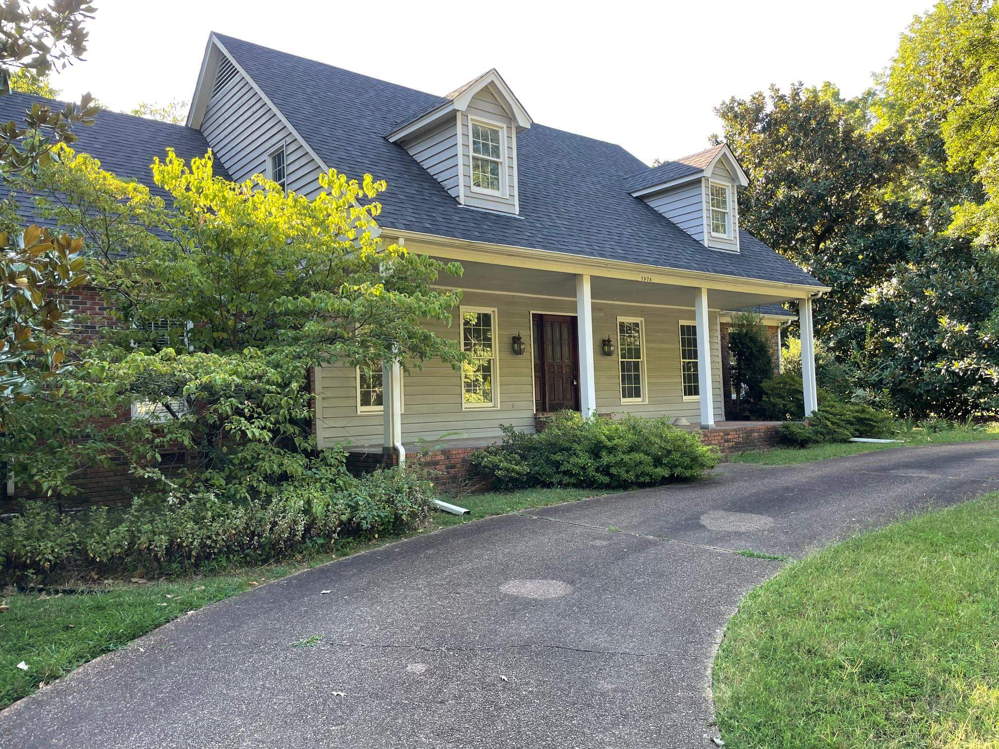 Cape cod home featuring covered porch