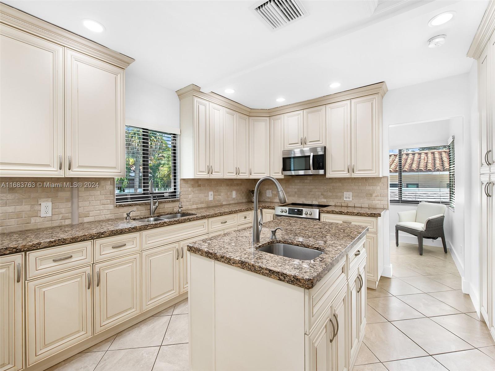 a kitchen with sink a microwave and cabinets