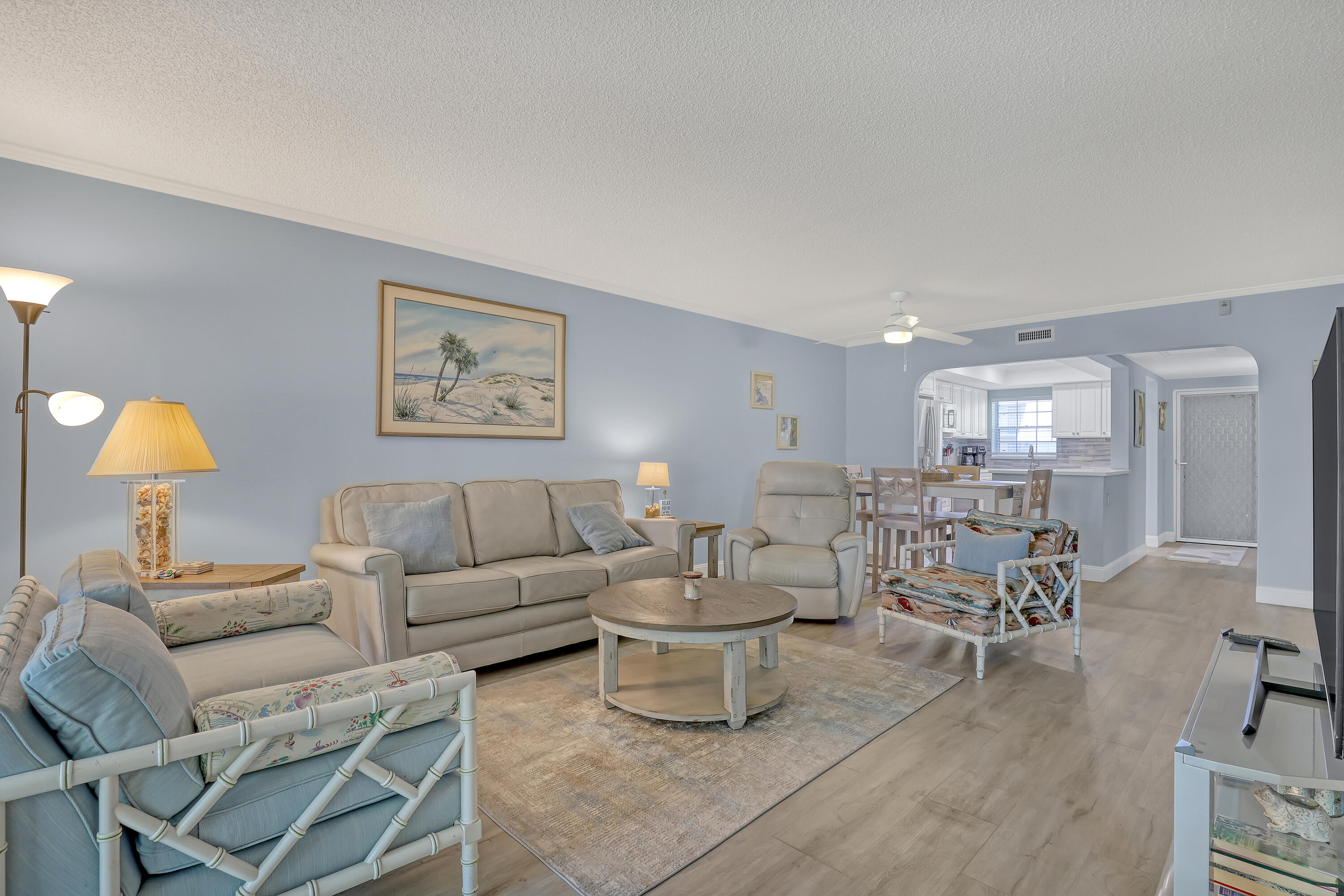 a living room with furniture and lamp painting on the wall