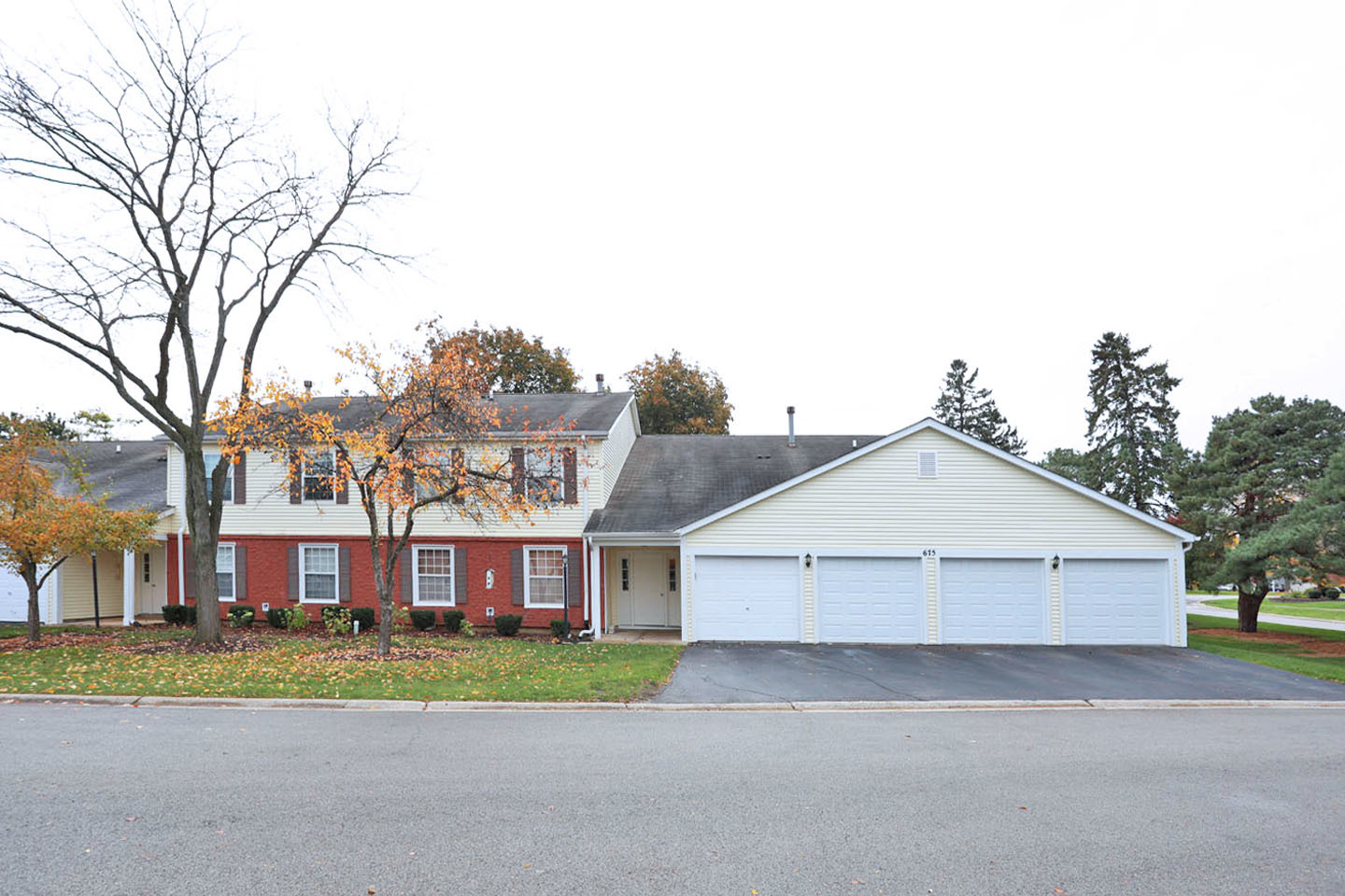 a view of a house with a yard and large tree