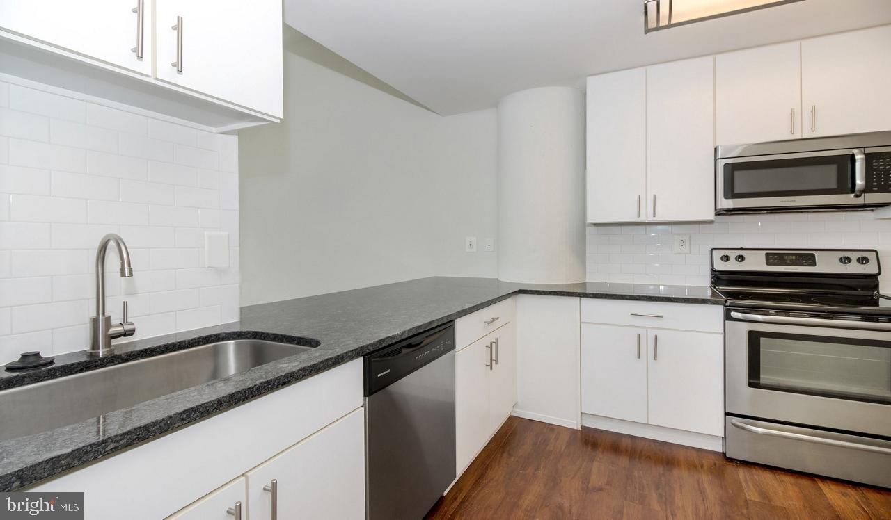 a kitchen with granite countertop a sink and stainless steel appliances