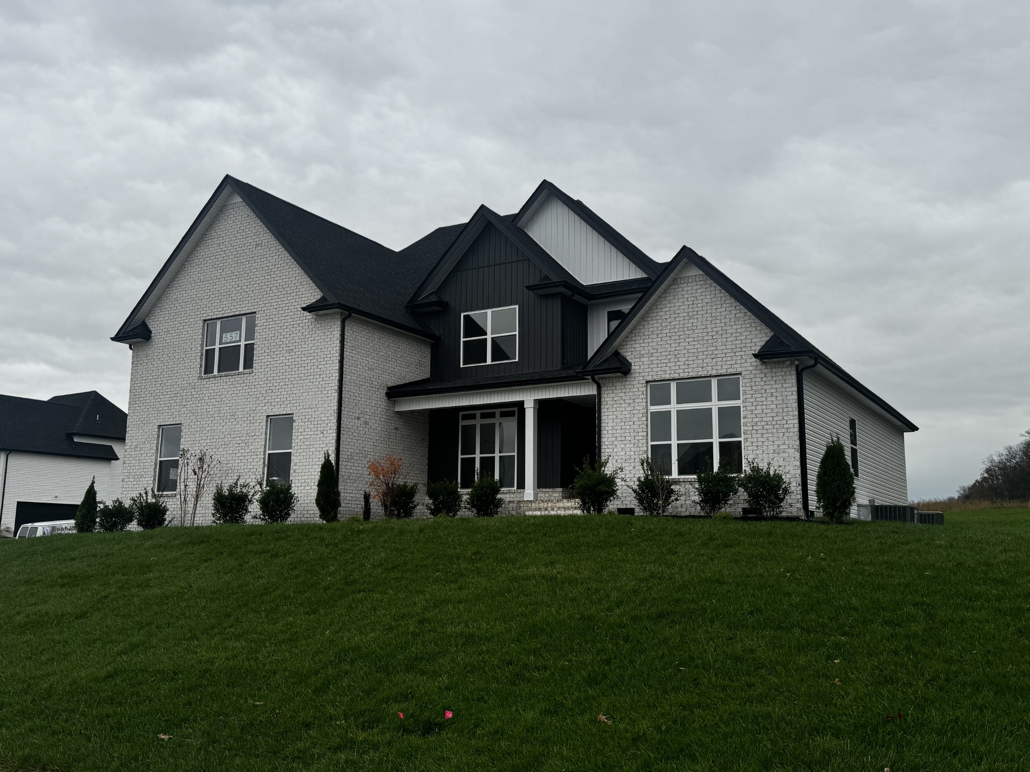 a front view of a house with a garden and trees