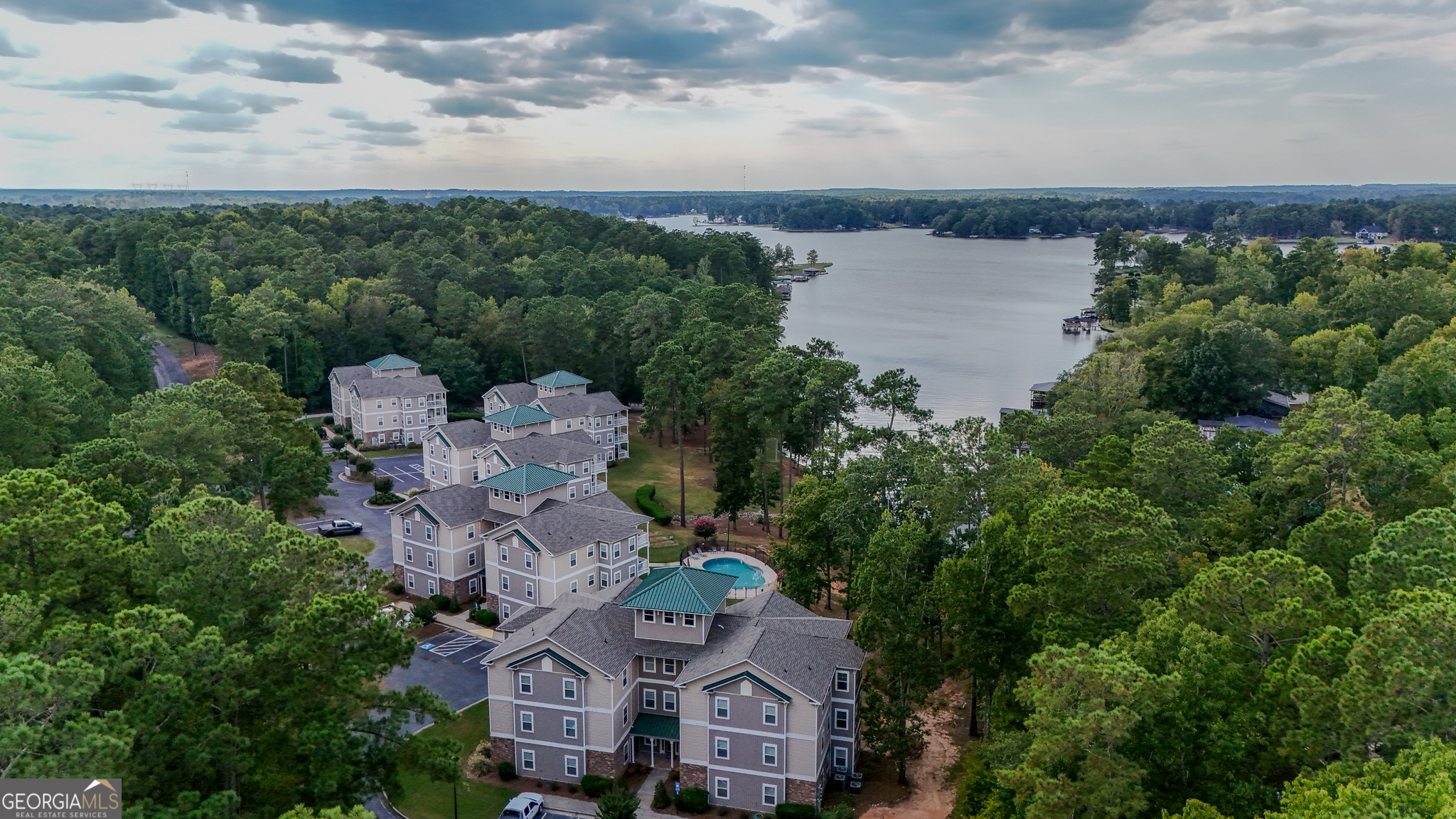 an aerial view of a house with a garden and lake view