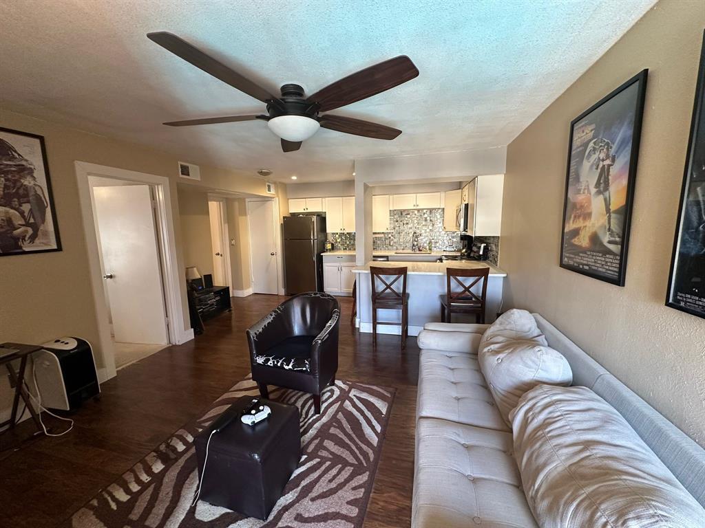 a living room with stainless steel appliances furniture and a large window