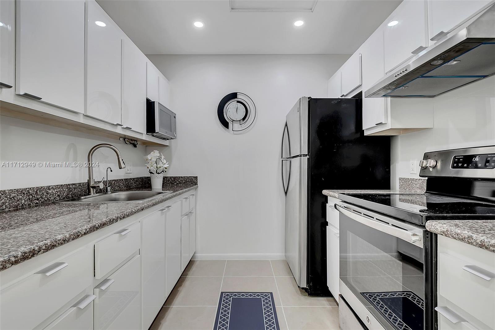 a kitchen with stainless steel appliances granite countertop a refrigerator and a sink