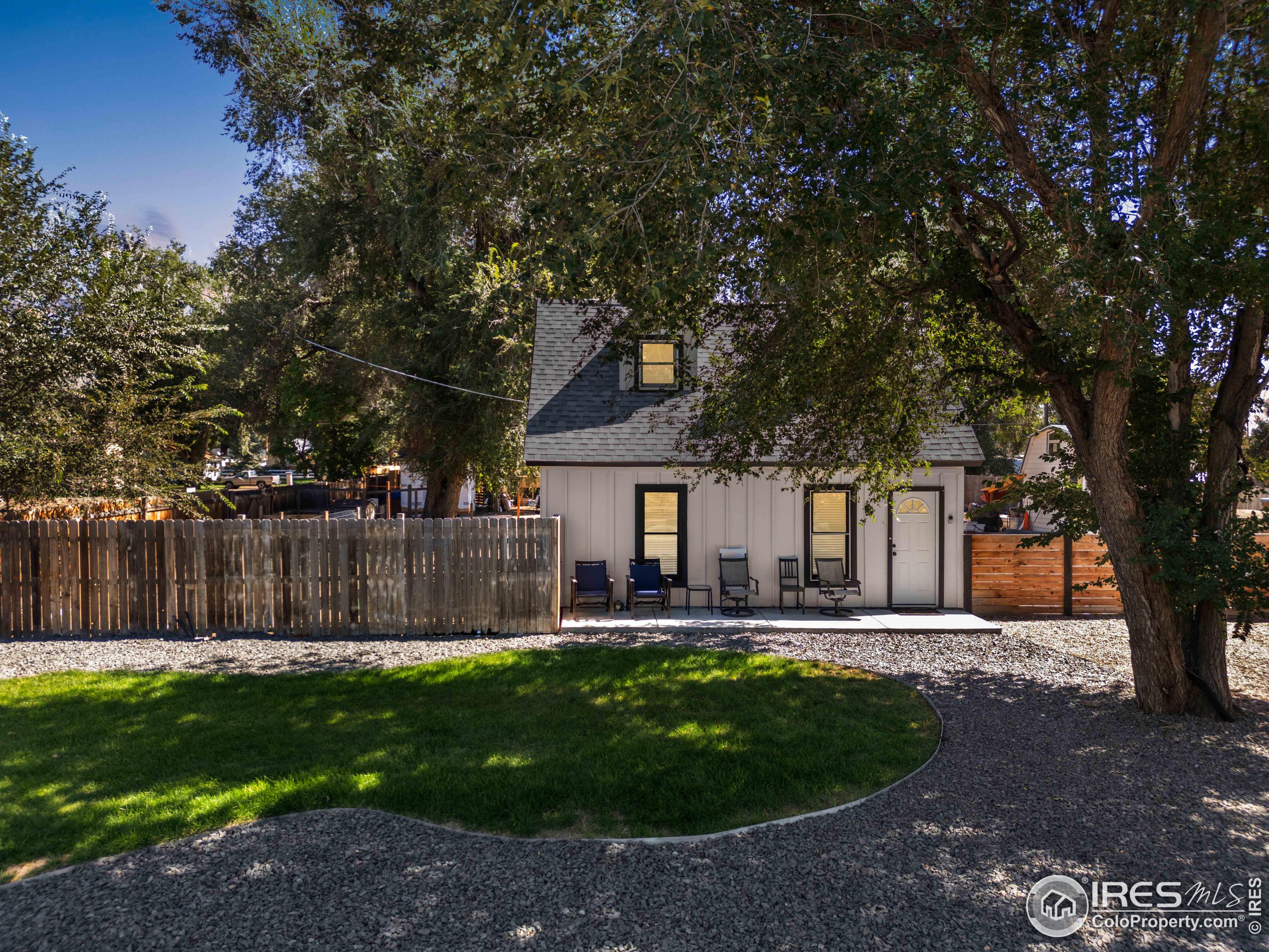 a front view of a house with a yard garden and outdoor seating