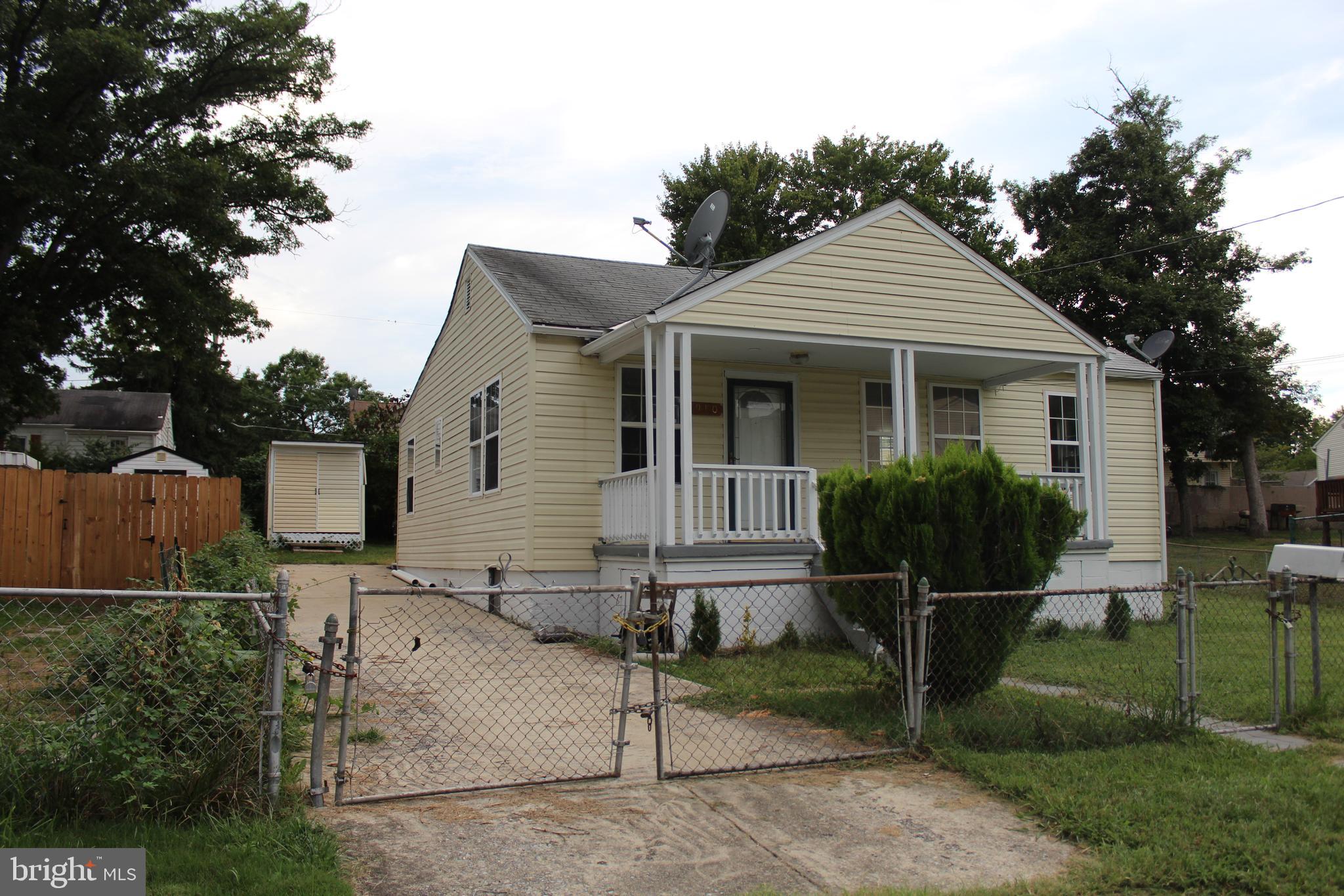 a view of a house with wooden fence next to a yard