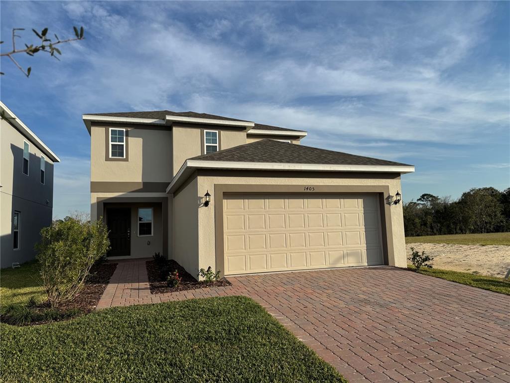 a front view of a house with a yard and garage