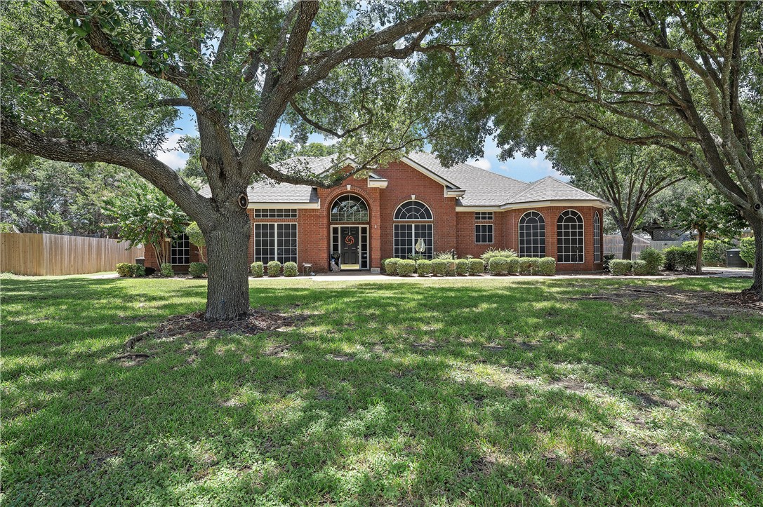 a front view of a house with a garden and trees