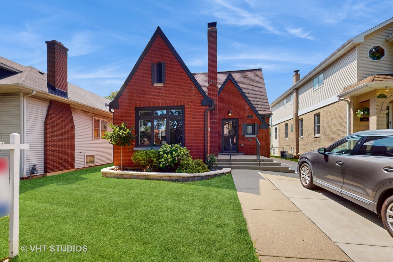 a front view of a house with a garden and plants