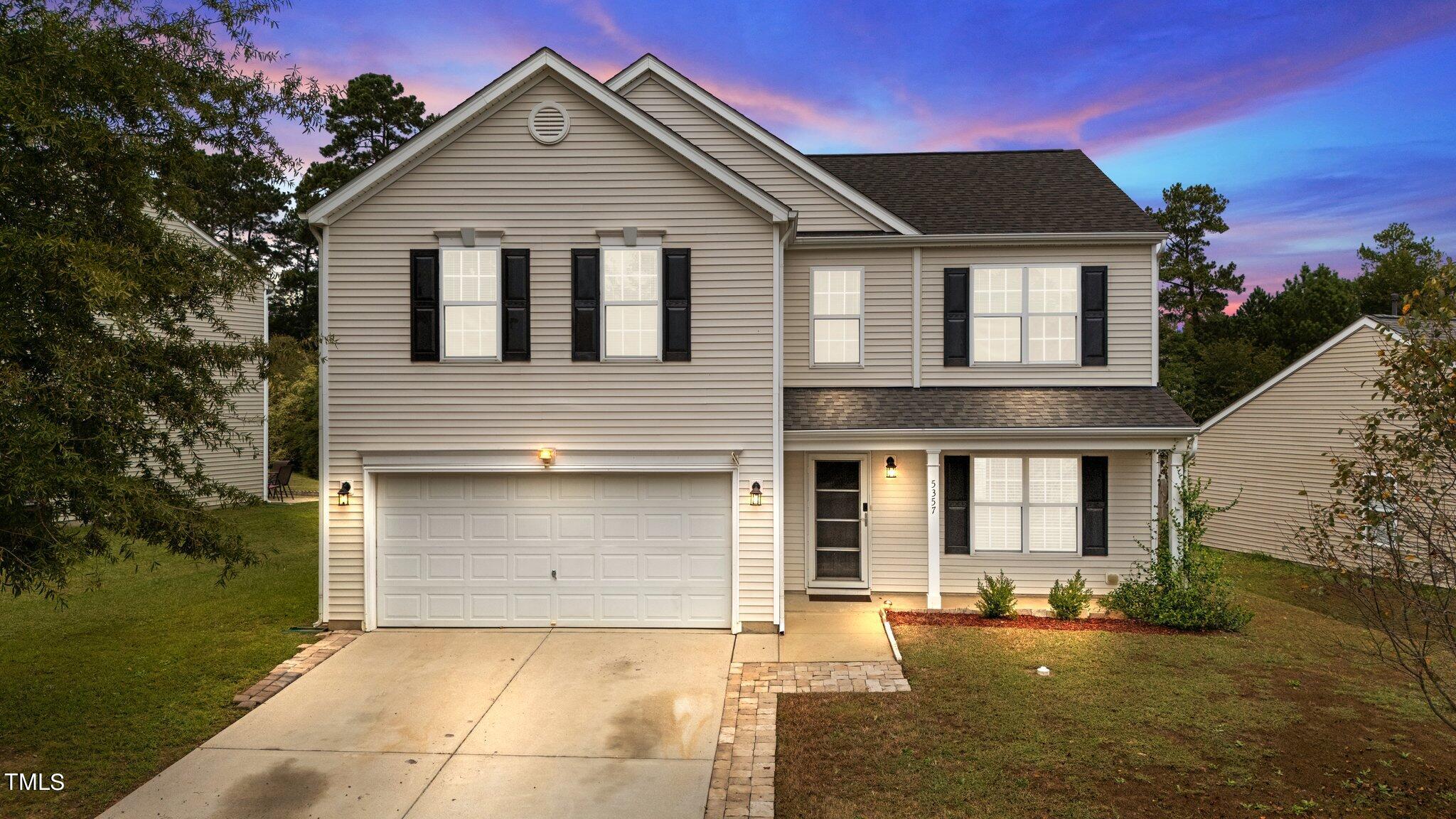 a front view of a house with a yard and garage