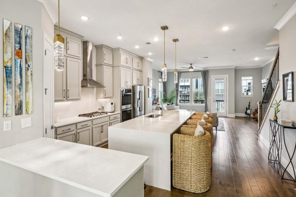 a large kitchen with stainless steel appliances lots of counter space and wooden floor