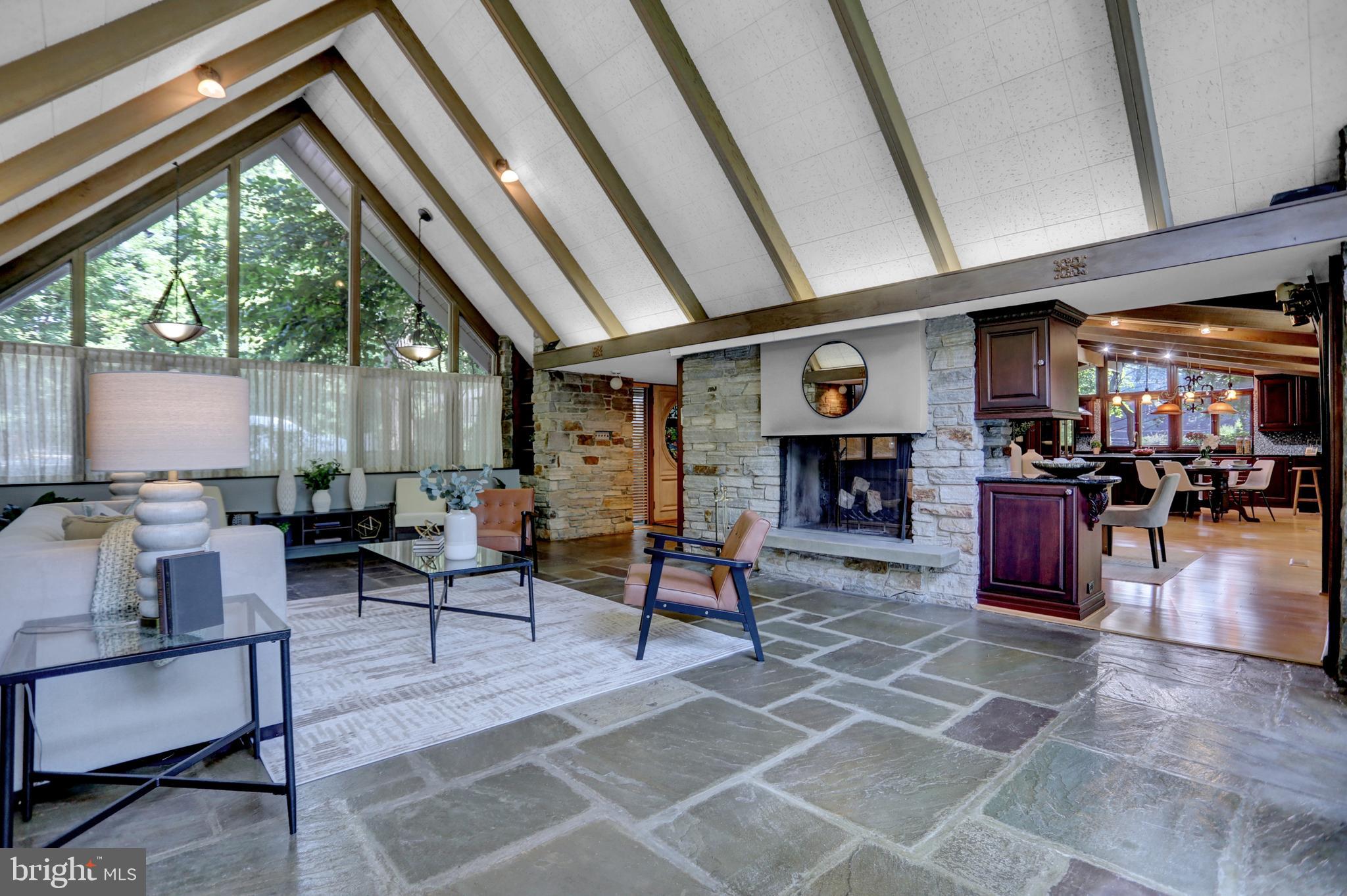 a living room with fireplace furniture and a large window