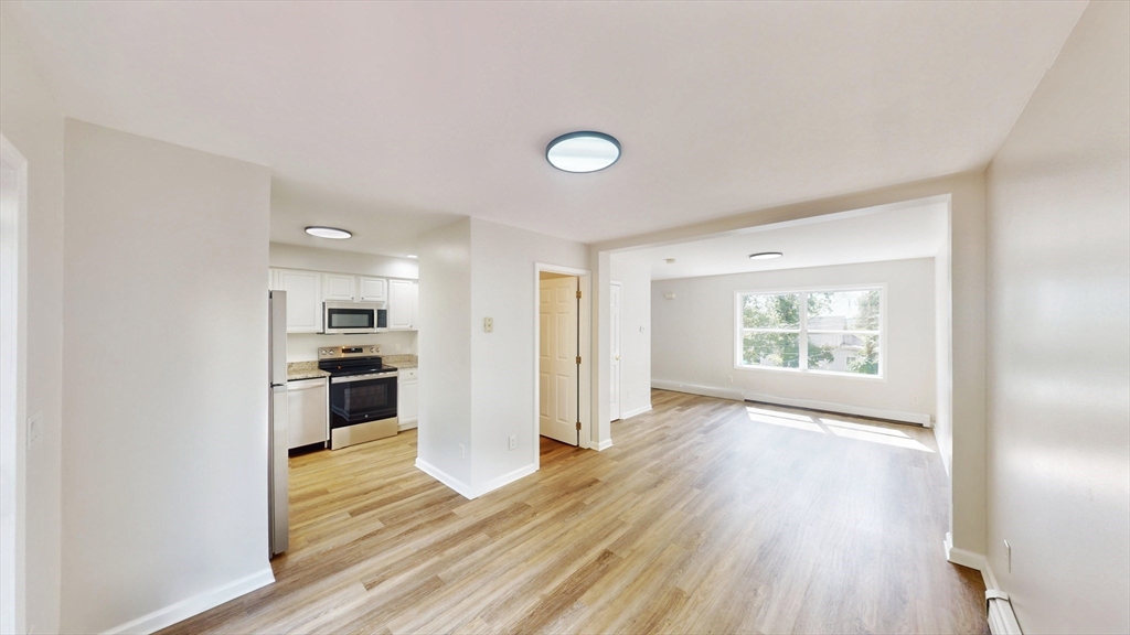 an empty room with wooden floor and a window