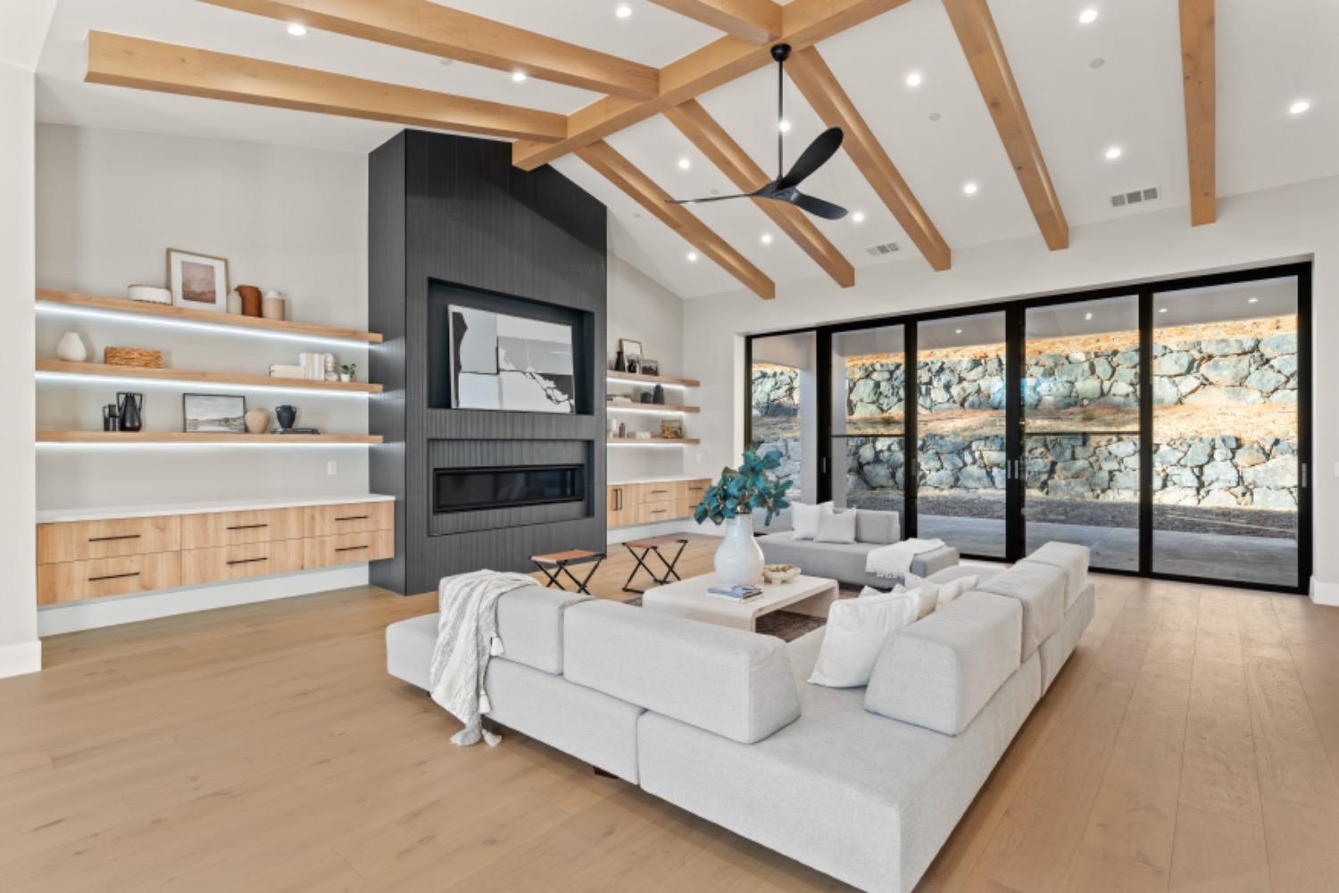 a living room with furniture large window and a fireplace