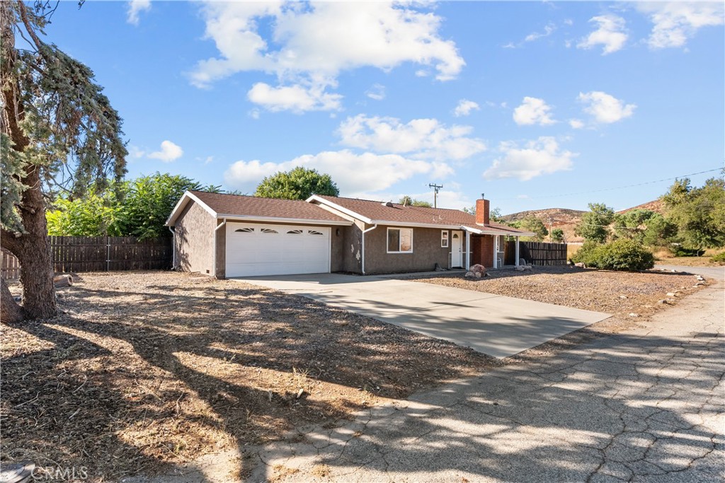 a front view of a house with a yard and trees