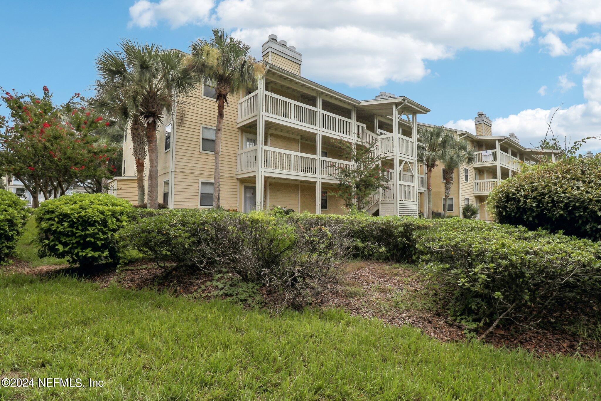 a view of a residential apartment building with a yard