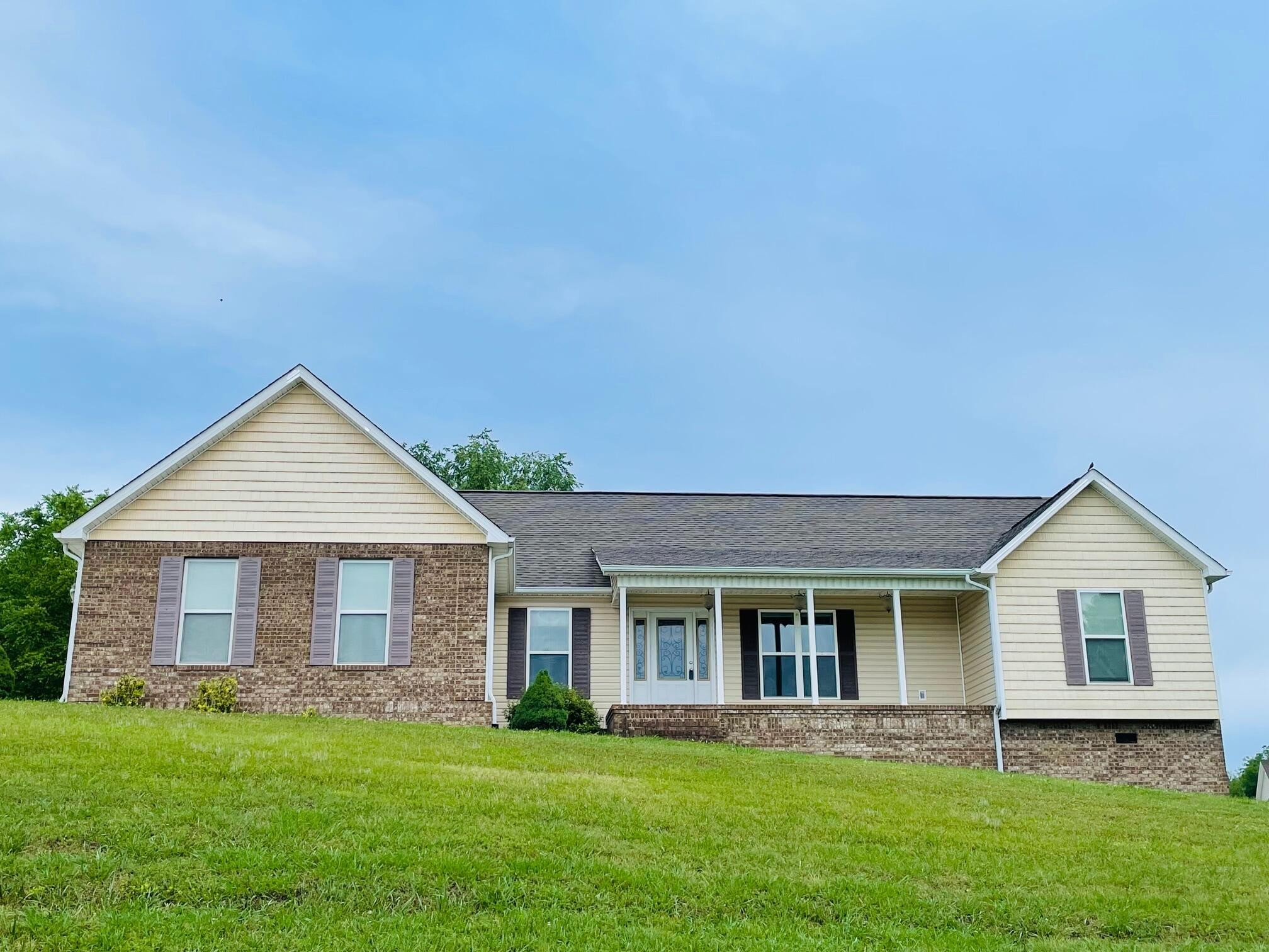 a front view of a house with a garden and yard