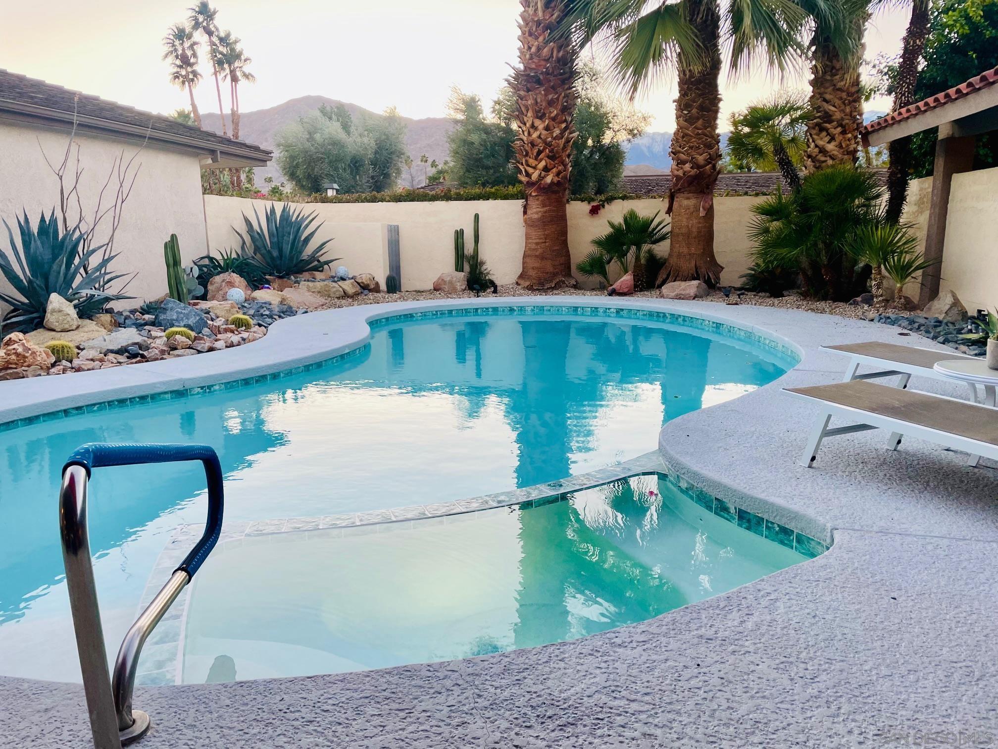 a view of a swimming pool with a patio and a yard