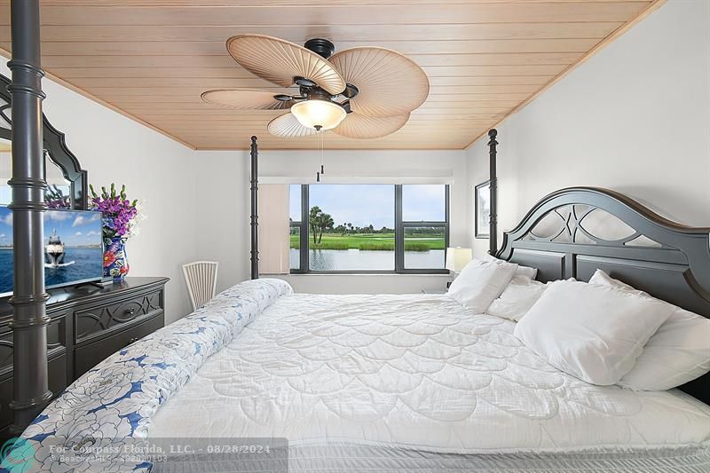 a bedroom with a bed mirror and a large window